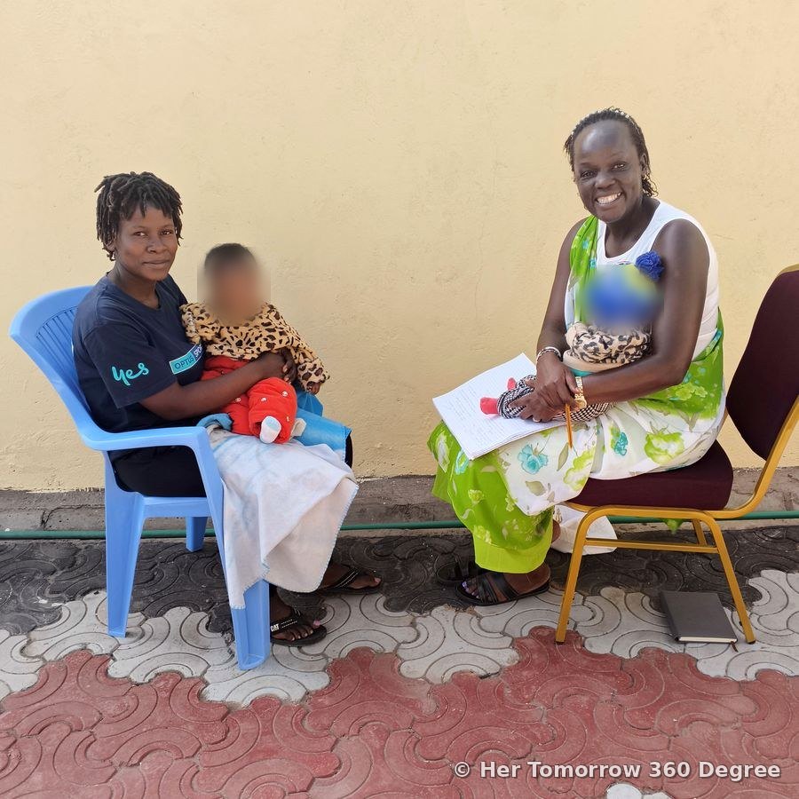 A young mother with her baby in a consultation with a smiling Lyma Kivali