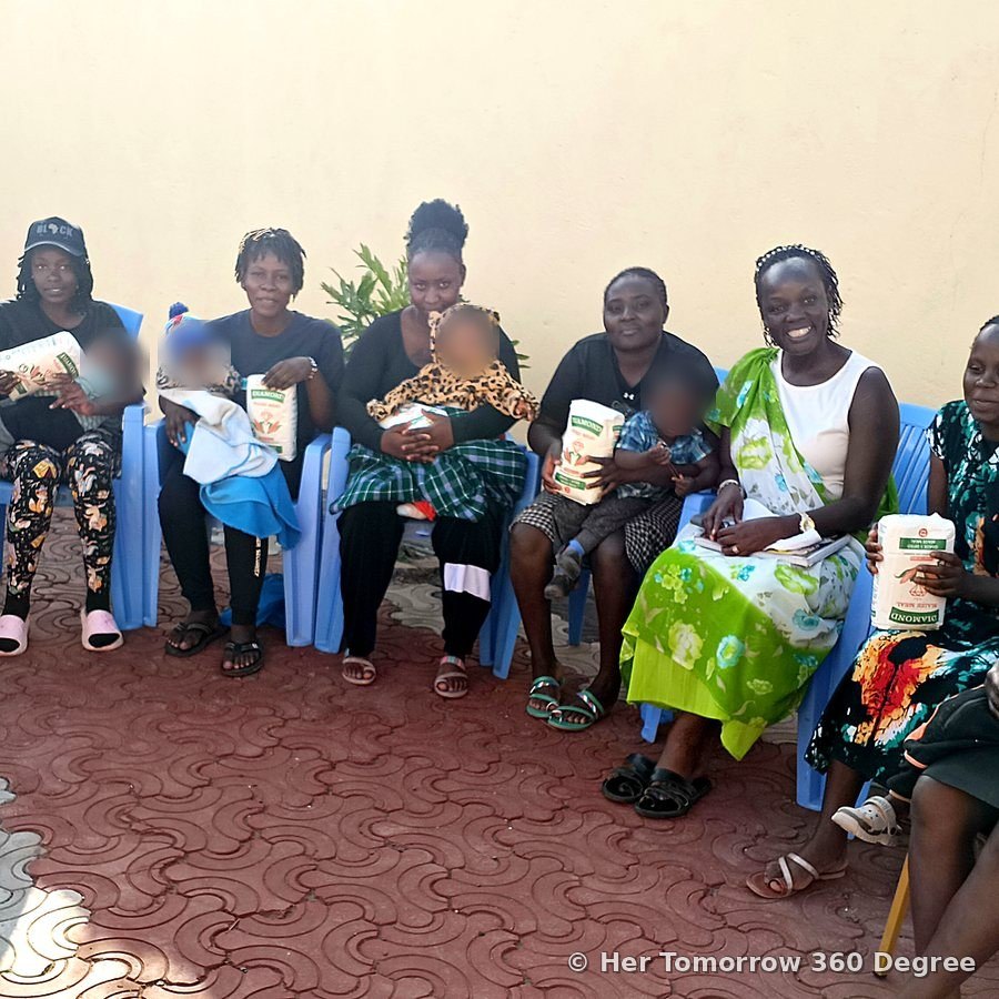 Young mothers and their babies seated together in a semicircle at the Chief's Office, Olkeri, each holding a packet of unga (ugali flour)