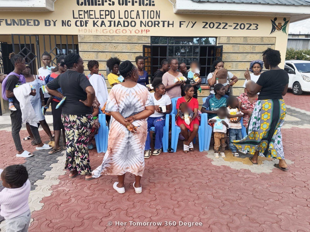Founder Lyma Kivali, in a kitenge skirt, speaks to mothers outside the Chief's Office
